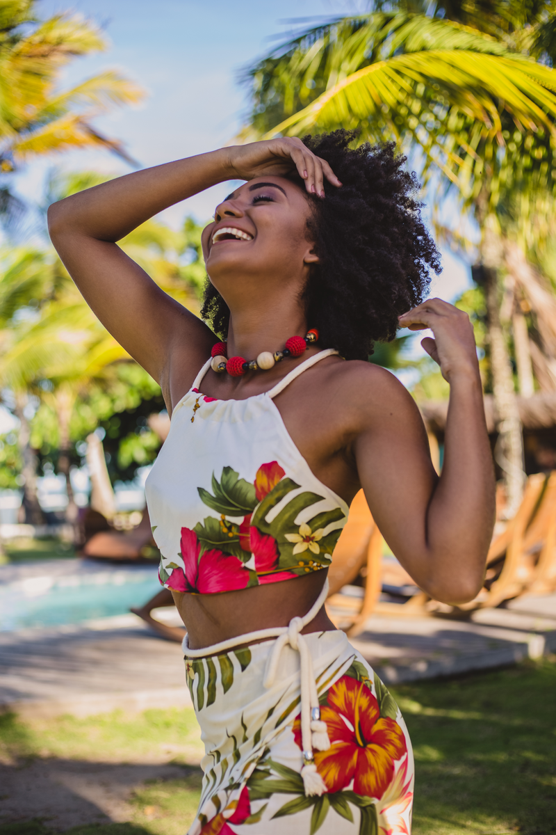 Happy black woman in stylish wear near palm trees